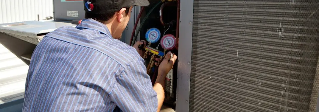 HVAC technician servicing a condenser unit in Airmont