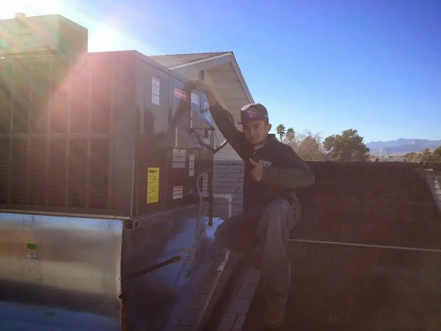 HVAC technician performing Heat Pump Repair on a rooftop unit in Airmont